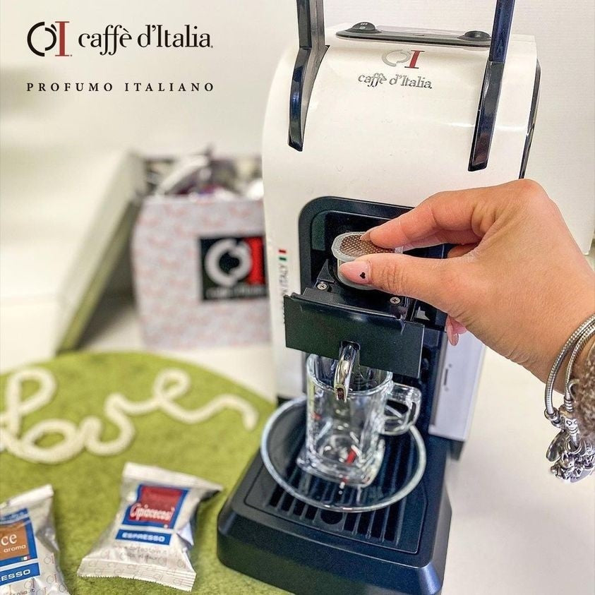 Caffe D'Italia UK - CoffeHome BIRBA white capsule coffee machine with a hand inserting a capsule into the brewer